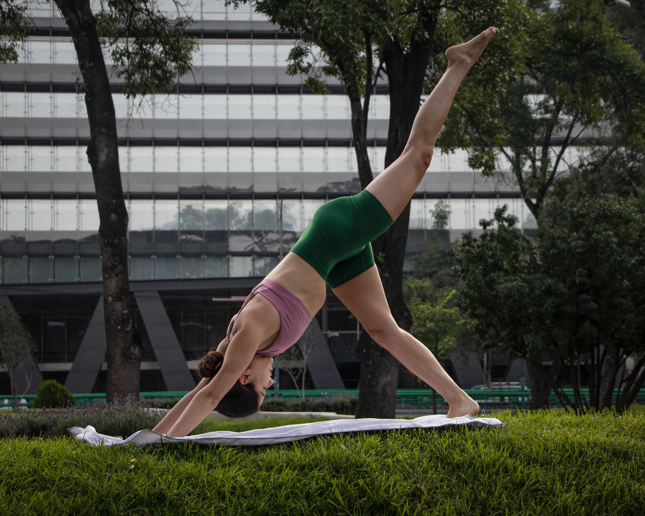 contact-img A woman practicing yoga in a park in Mexico City, showcasing balance and flexibility.